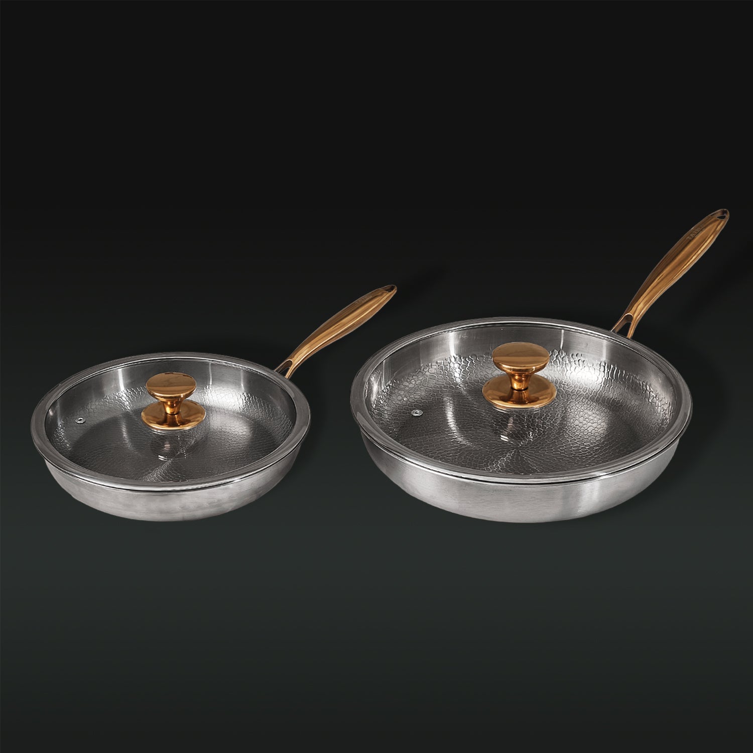 Two Titanium frying pans with golden handles on a black background